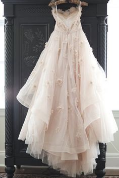 a dress hanging on a rack in front of a mirror