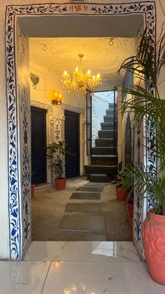 an entry way with stairs and potted plants on either side, leading up to the second floor