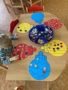 a little boy that is sitting at a table in front of some plates and bowls