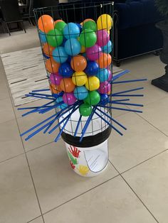 a basket filled with balloons sitting on top of a tiled floor