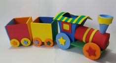 a colorful wooden toy train with stars on the front and sides, sitting on a white surface