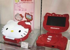 two hello kitty toys are on display in a store window, one is red and the other is white