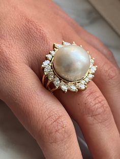 "Vintage pearl and diamond ring set in 18 karat solid yellow gold. The pearl is set with over 3 carats in marquise and round-cut diamond halo. This South Sea Pearl bears a vibrant white luster with little to no blemishes. The perfect heirloom piece that echoes a statement of refined class and taste. Polished finish for extra brilliance and shine. Certificate of appraisal included upon request. Ring Details: ✔ Ring Size: 7.5 U.S. (adjustable) ✔ Ring Weight: 20.3 grams ✔ Gold Purity: 18K Pearl Det Pearl Rings In Gold Vintage, Pearl And Diamond Ring, Mabe Pearl, Vintage Pearl, Diamond Ring Settings, Marquise Cut Diamond, Sea Pearl, Detailed Ring, South Sea Pearls