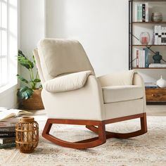 a living room with a rocking chair and bookshelf