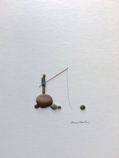 a man standing on top of a rock next to a fishing pole