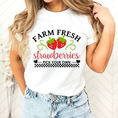 "Featuring the phrase \"Farm Fresh Strawberries - Pick Your Own\" in a charming and inviting design, this t-shirt captures the essence of a sunny day at the strawberry patch. It's a perfect choice for those who appreciate the goodness of locally grown produce and want to celebrate the experience of hand-selecting the juiciest strawberries. Crafted with care from soft, comfortable fabric, this t-shirt ensures a cozy fit while you embark on your strawberry-picking adventures. Its versatile design Fun Cotton T-shirt With Strawberry Print, Fruit T Shirt, Farmers Market Shirt, Strawberry Shirt, Strawberry Picking, Cottagecore Shirt, Strawberry Patch, Fresh Strawberries, Locally Grown