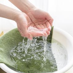 a person washing their hands in a sink with water coming from the faucet