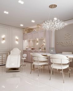 the interior of a nail salon with white furniture and chandelier hanging from the ceiling