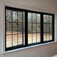 an empty room with two windows and a sink in the corner on the far side