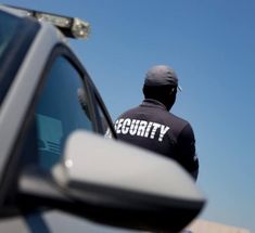 a security officer standing next to a car