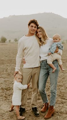 a man, woman and child are standing in the dirt