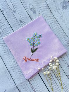 a purple cloth with embroidered flowers on it