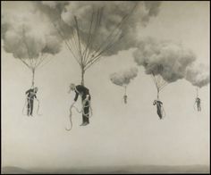 several people are suspended in the air with parachutes attached to their backs and feet