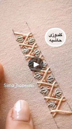 someone is stitching on the side of a piece of fabric with their thumbnails