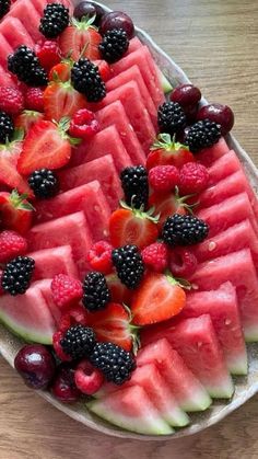 slices of watermelon, strawberries and blackberries arranged on a platter