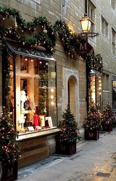 christmas decorations adorn the windows of this store