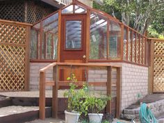 a house that has some plants in front of it and stairs leading up to the roof