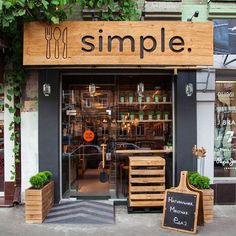 an outside view of a restaurant called simple with wooden crates and plants in the window