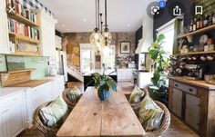 a dining room table with chairs around it in front of an open kitchen and living area