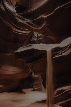 an image of a waterfall in the middle of a canyon with light coming from it