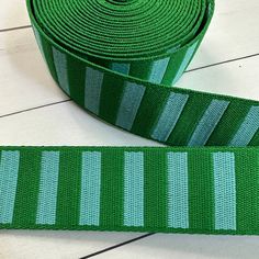 a roll of green ribbon sitting on top of a white floor