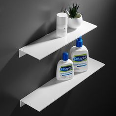 two white shelfs with cleaning products and a potted plant on one side, against a gray wall