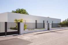 a white house with black fence and trees