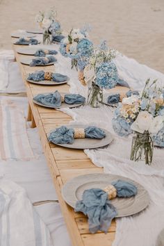 a long table with plates and flowers on it