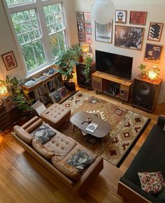 an overhead view of a living room with couches, coffee table and television in it