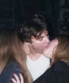 two people kissing each other in front of a crowd