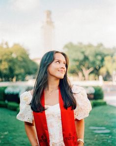 a woman standing in front of the eiffel tower wearing a red and white dress