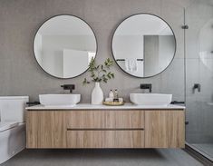 a bathroom with two round mirrors on the wall