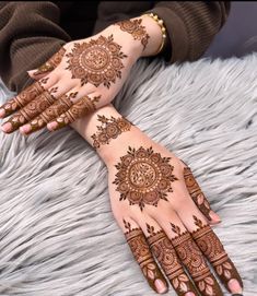 two hands with henna tattoos on them