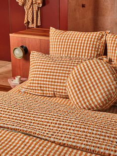 an orange and white checkered bedspread with matching pillow cases in a bedroom