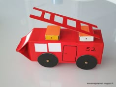 a paper model of a firetruck on a white table with the number 52 painted on it