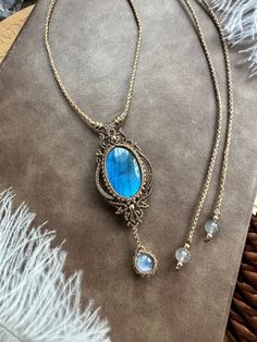 a necklace with a blue stone hanging from it's side on a fur rug