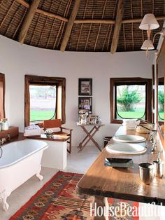 a bathroom with a bathtub, sink and table in it's center area