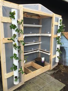 an outdoor potting shed with plants growing out of the top and bottom shelves on each side