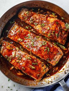 baked salmon fillets in a pan with sauce and seasoning