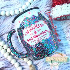 the mug is decorated with colorful sprinkles and frosting on it's side