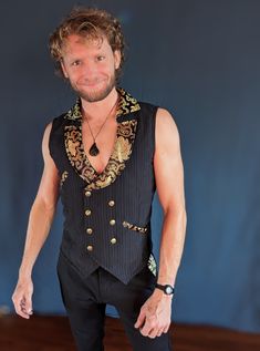 Built to last with quality materials, this "Upscale Tribal" double breasted men's vest is truly special. Every detail has been selected to be complementary.  This vest features  ~a wide lapel with an eye catching gold print material ~a classic subtle pin stripe for the body ~The material is a little stretchy so it looks good well fitted -quite adjustable in the back ~gorgeous brass buttons with the sri yantra symbol, and REAL pockets!  Looks great by itself or over a long sleeve shirt.  Can be c Steampunk Style Sleeveless Black Vest, Steampunk Black Sleeveless Vest, Black Steampunk Sleeveless Vest, Black Sleeveless Steampunk Vest, Steampunk Formal Sleeveless Vest, Formal Steampunk Sleeveless Vest, Formal Sleeveless Steampunk Vest, Steampunk Sleeveless Vest With Buttons, Steampunk Fitted Vest With Buttons