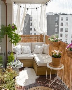 an outdoor living area with wicker furniture and potted plants on the roof terrace