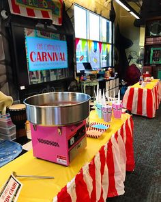 a carnival themed table set up with cupcakes, candy and ice cream cones