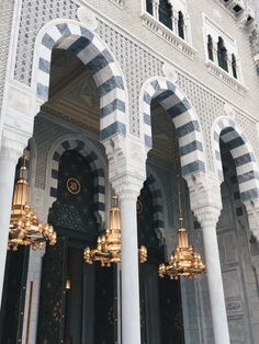 the interior of an ornate building with gold chandeliers and arches in front of it