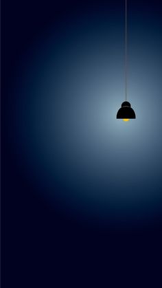 a black and yellow light hanging from a ceiling in a dark room with blue walls