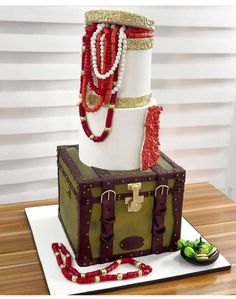 a cake made to look like a trunk with jewelry on top and beads around it