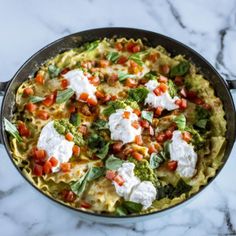 an omelet with tomatoes, spinach and feta cheese in a skillet