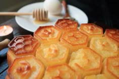 some honeycombs are sitting on a plate next to a fork and candle holder