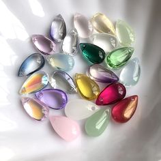 a white bowl filled with lots of different colored glass drops on top of each other