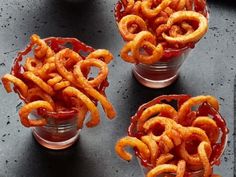 three cups filled with onion rings on top of a table